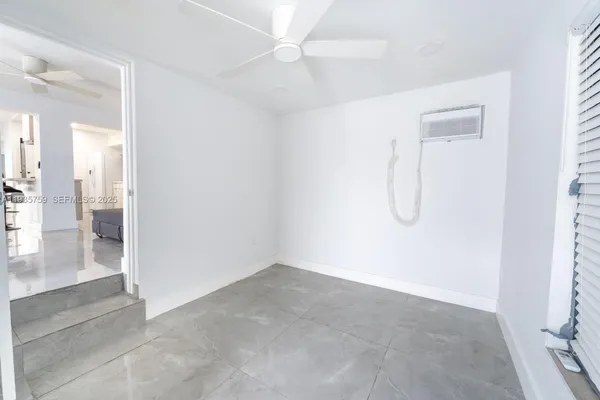 a view of a room with wooden floor and a ceiling fan