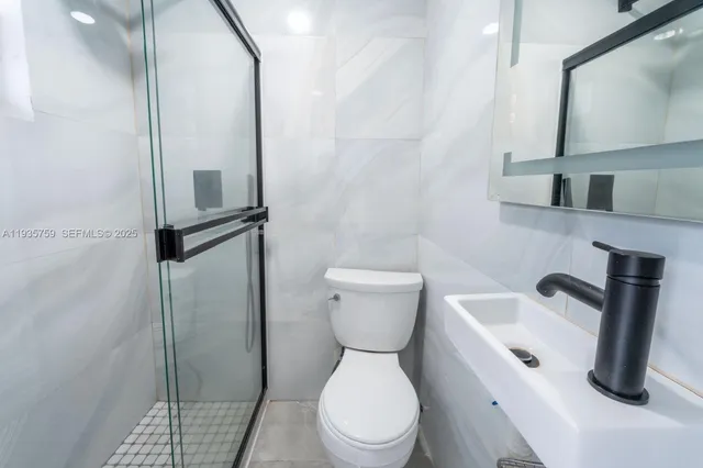 a white toilet sitting next to a bathroom sink