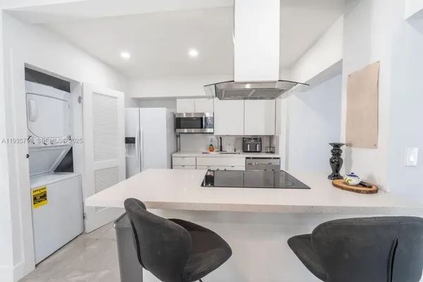 a kitchen with kitchen island a sink stove and refrigerator