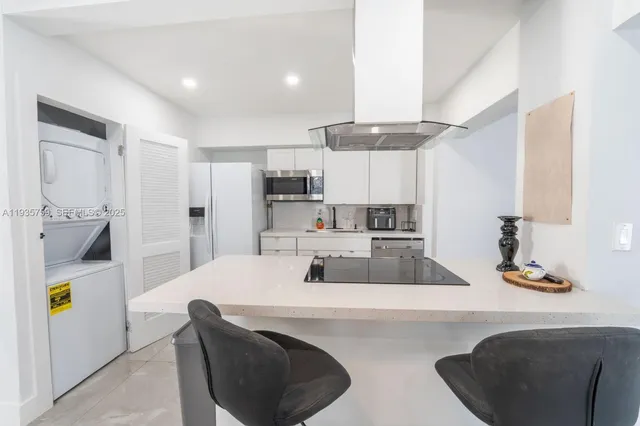 a kitchen with kitchen island a sink stove and refrigerator