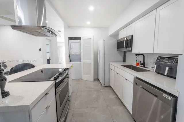 a kitchen with stainless steel appliances granite countertop a sink stove and refrigerator