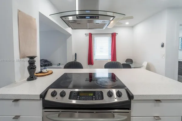 a kitchen with a stove and a white cabinets