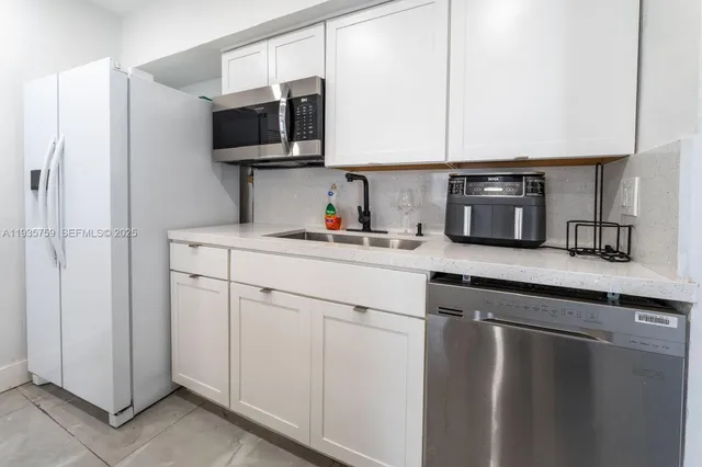 a kitchen with a sink microwave and cabinets