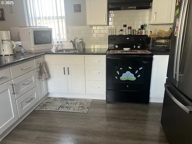 a kitchen with granite countertop white cabinets and appliances