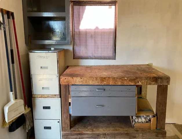a white refrigerator with a white table and a painting on it