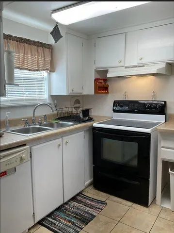 a kitchen with granite countertop a stove sink and cabinets