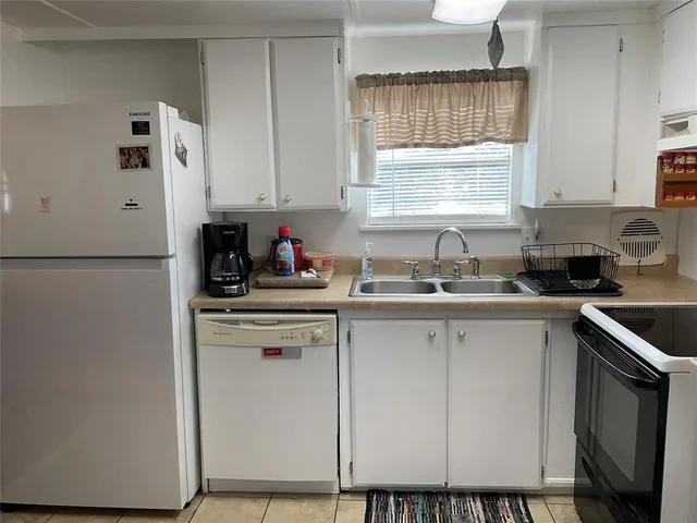 a kitchen with a refrigerator and white cabinets