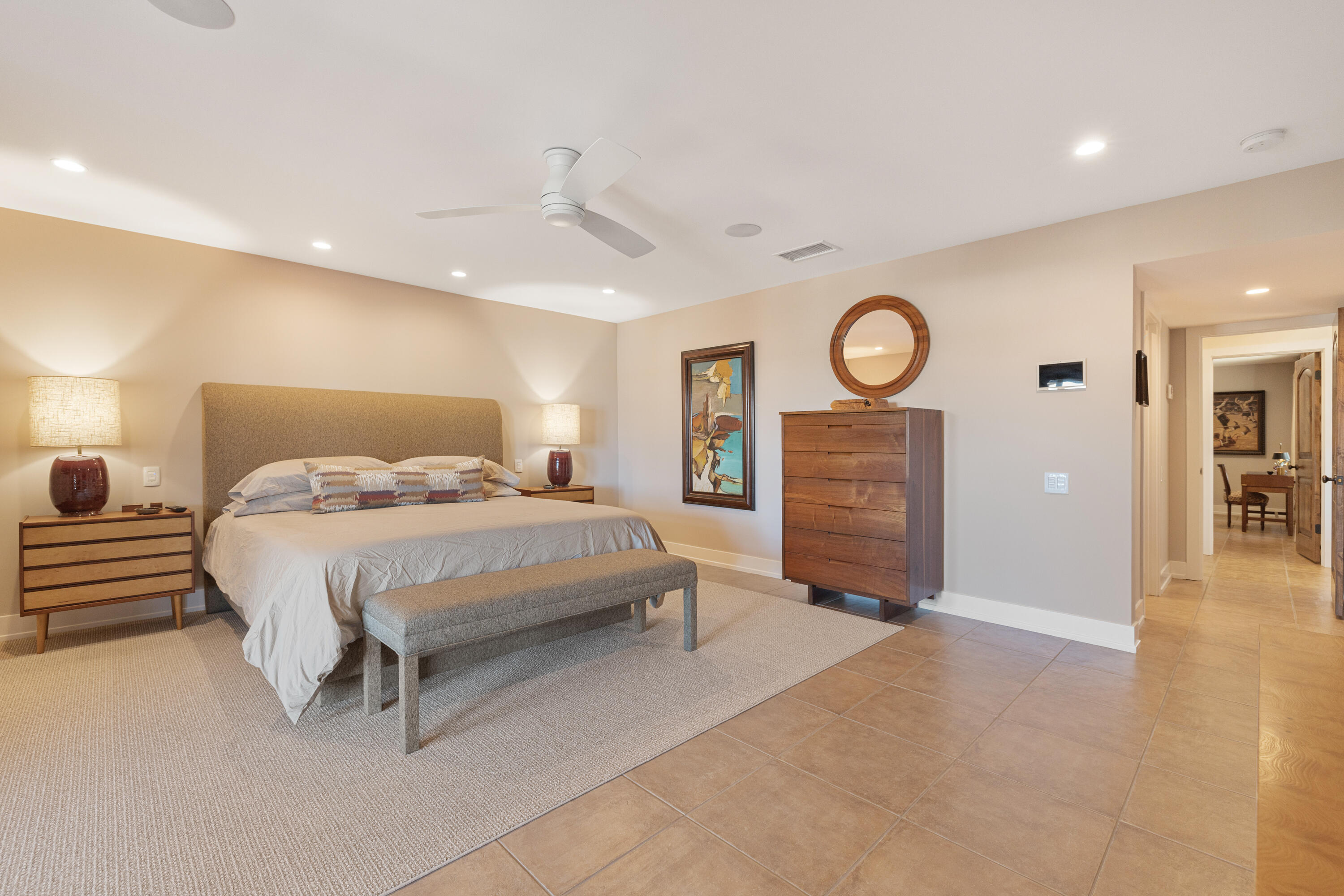 40170 Paseo Lindo Rancho Mirage, CA 92270 - Photo 36 of 51 a spacious bedroom with a bed a clock and a ceiling fan