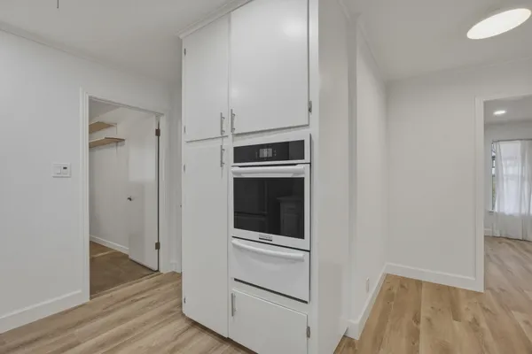 a view of kitchen and hallway with wooden floor
