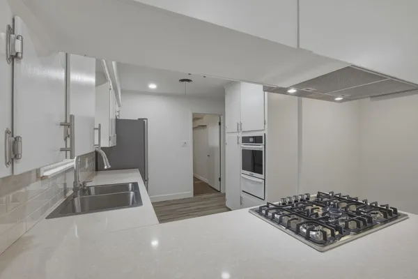 a kitchen with stainless steel appliances granite countertop a refrigerator and a sink