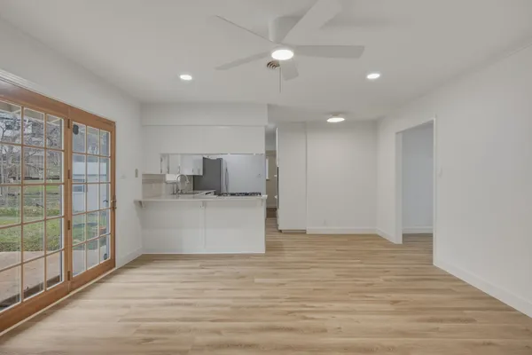 a view of kitchen with stainless steel appliances wooden floor and window