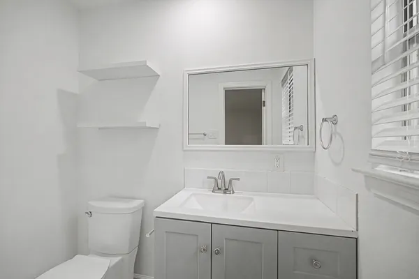 a bathroom with a toilet sink and mirror