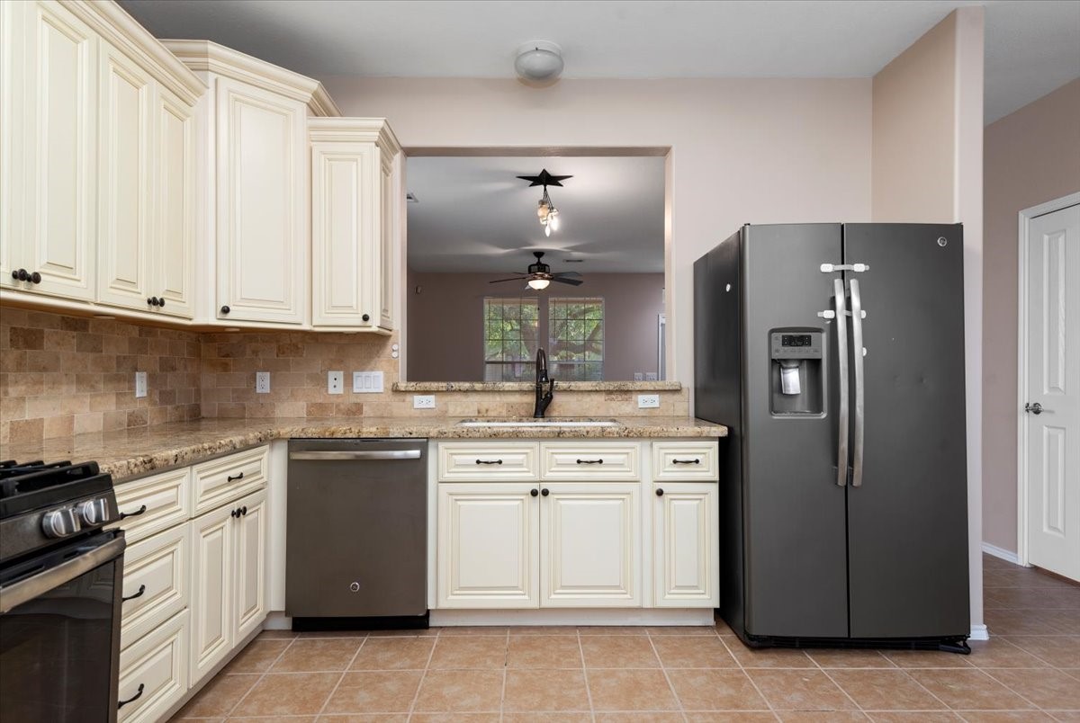 23611 Youpon Lake Lane Spring, TX 77373 - Photo 11 of 25 a kitchen with stainless steel appliances granite countertop a stove a refrigerator and a sink