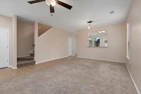 an empty room with windows and ceiling fan