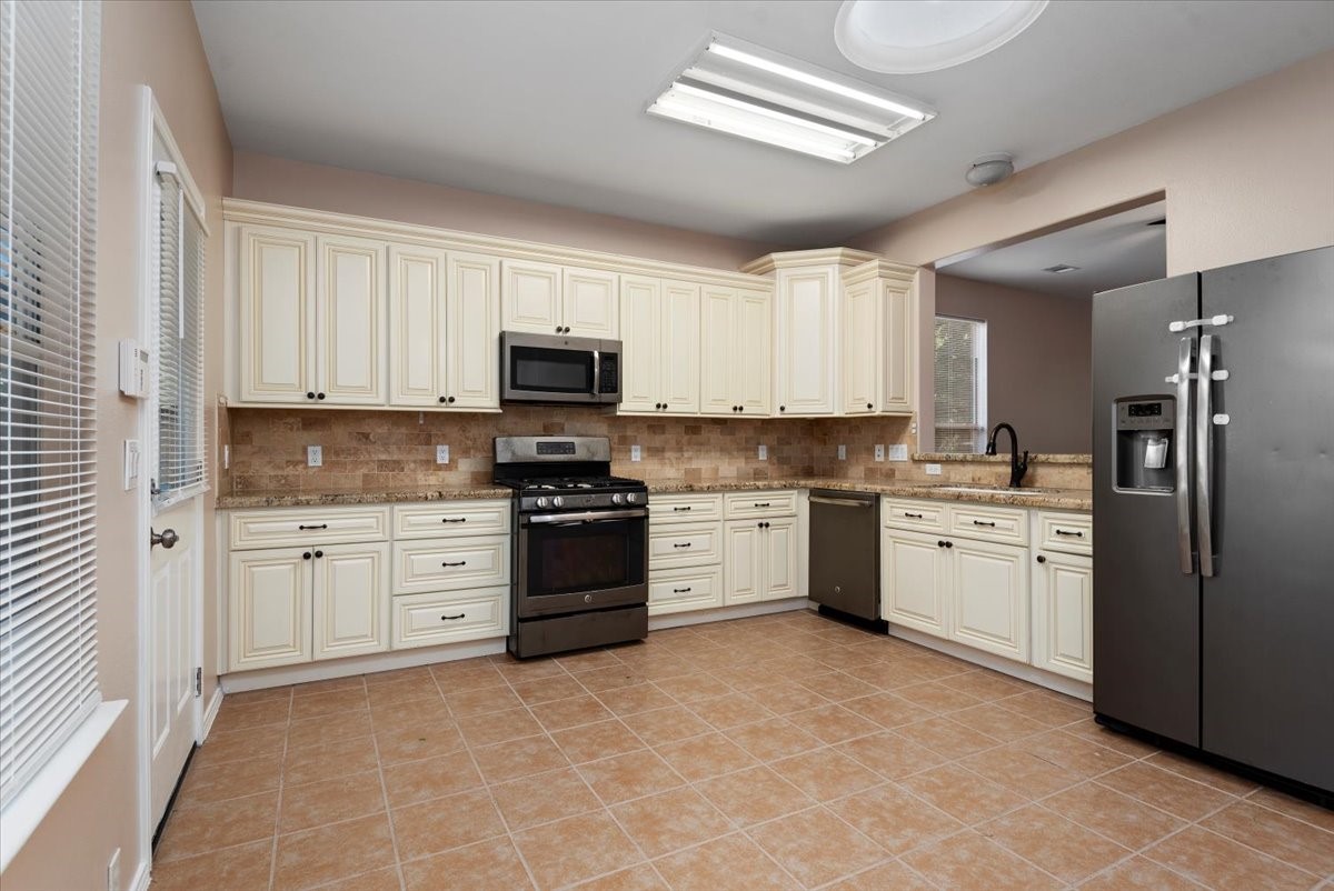 23611 Youpon Lake Lane Spring, TX 77373 - Photo 9 of 25 a kitchen with granite countertop white cabinets and stainless steel appliances