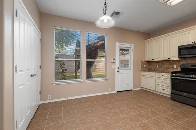 a view of kitchen with granite countertop cabinets and window