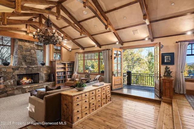 a living room with furniture a fireplace and a floor to ceiling window