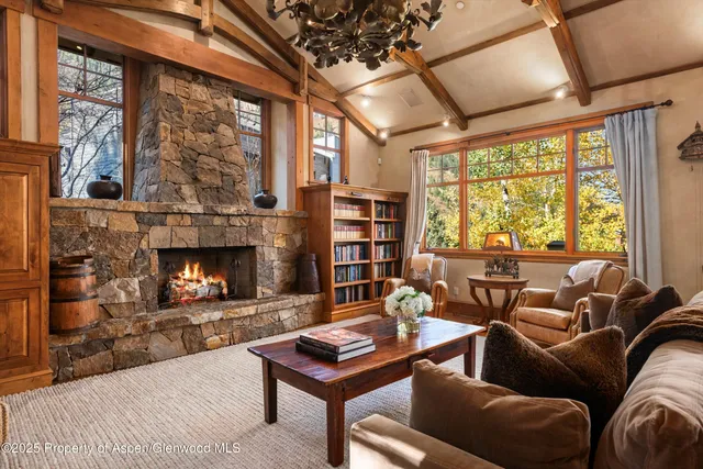 a living room with furniture a fireplace and a large window