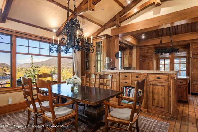 a dining room with furniture a chandelier and window