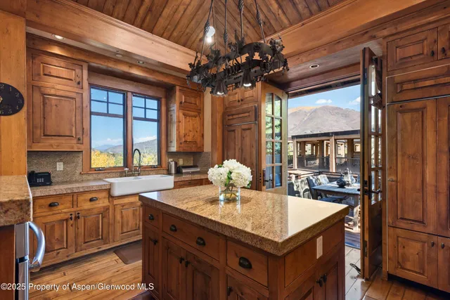 a kitchen with stainless steel appliances granite countertop a sink a stove and a wooden floors
