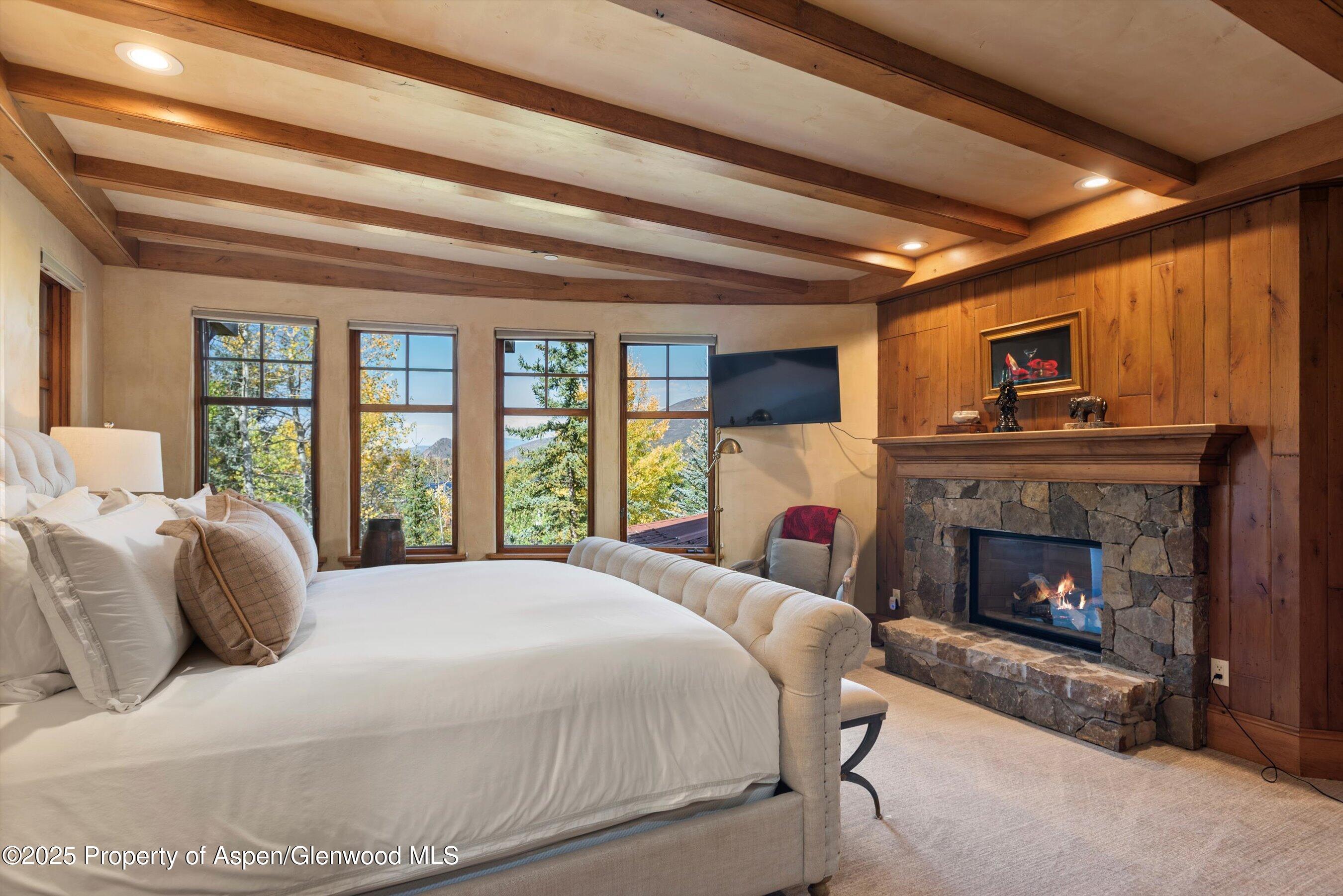 Aspen Central Core Aspen, CO 81611 - Photo 8 of 26 a bedroom with a bed and a fireplace