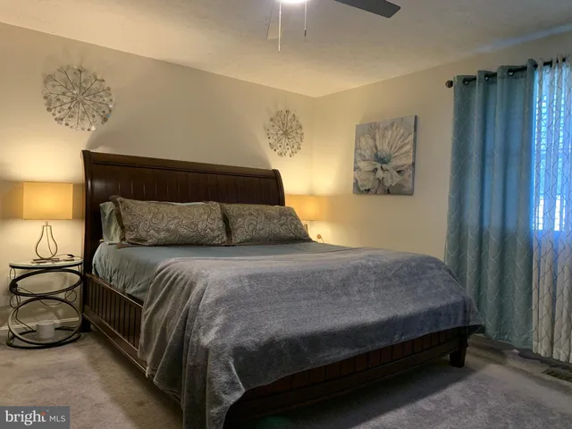 a bedroom with a bed and painting on the wall