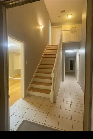 a view of staircase with railing and white walls
