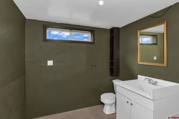 a bathroom with a sink a toilet and mirror