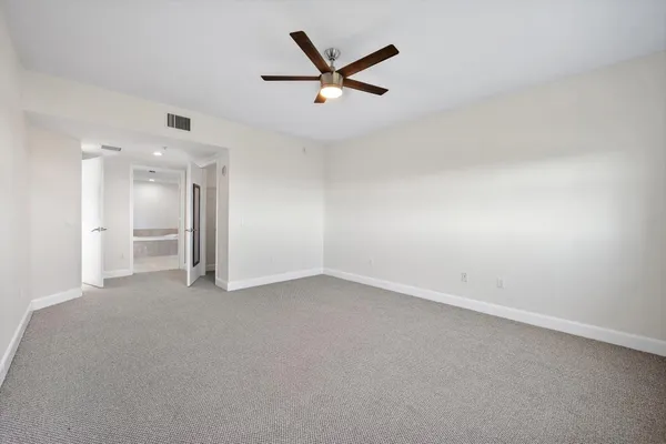 an empty room with closet and windows
