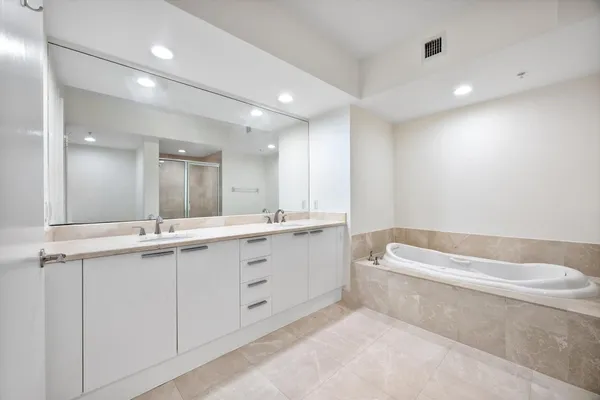 a bathroom with a tub a sink and mirror