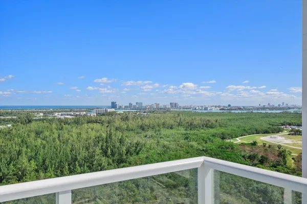 a view of a green field with mountains in the background
