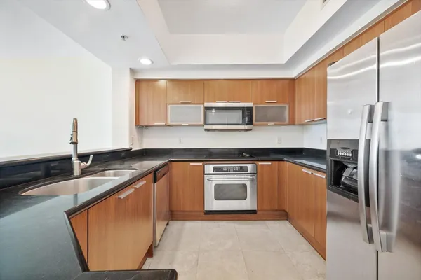 a kitchen with stainless steel appliances granite countertop a sink stove and refrigerator