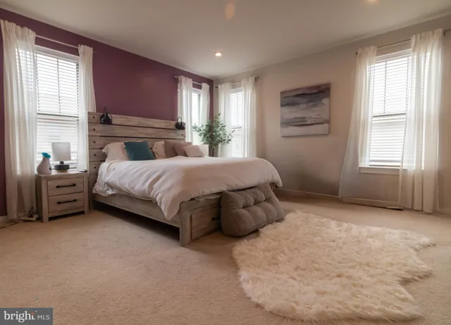 a bedroom with a bed a couch and large window