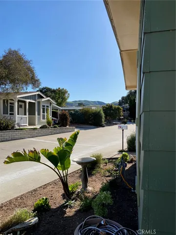 front view of house with a bench and potted plants