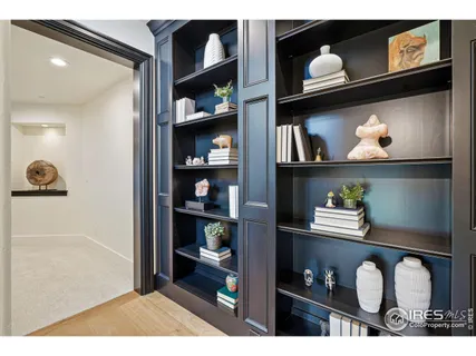 a living room with lots of painting and a book shelf