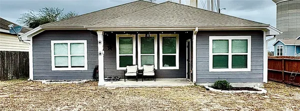 a front view of a house with a floor to ceiling windows and a chair