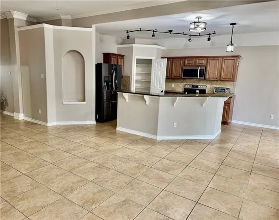 a view of kitchen with stainless steel appliances granite countertop a stove a sink and a microwave