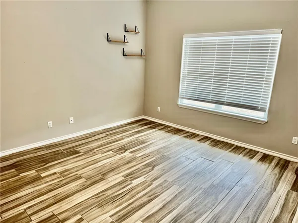 a view of a room with wooden floor and a window
