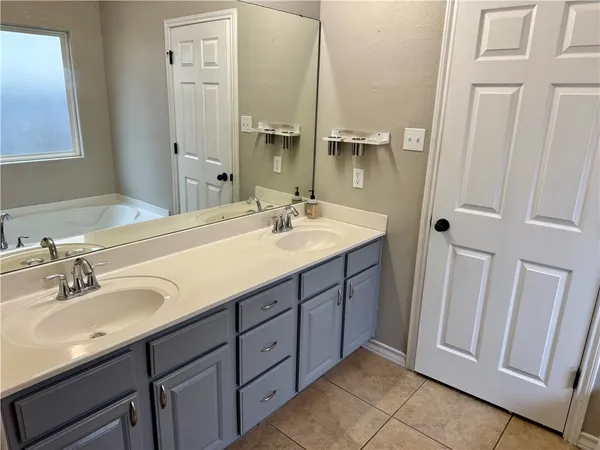 a bathroom with a double vanity sink and mirror