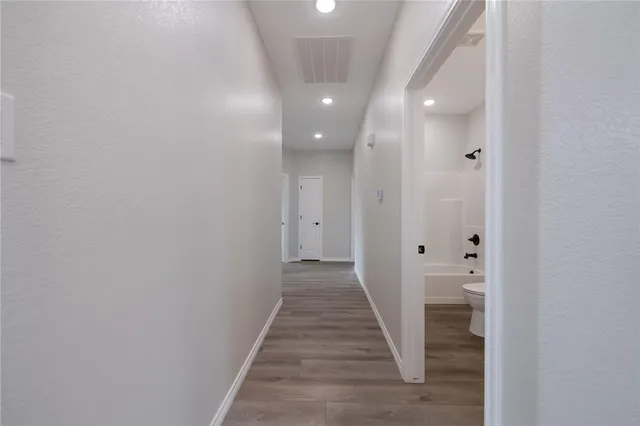 a view of a hallway with wooden floor