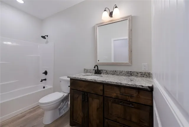 a bathroom with a granite countertop sink toilet a large mirror and shower