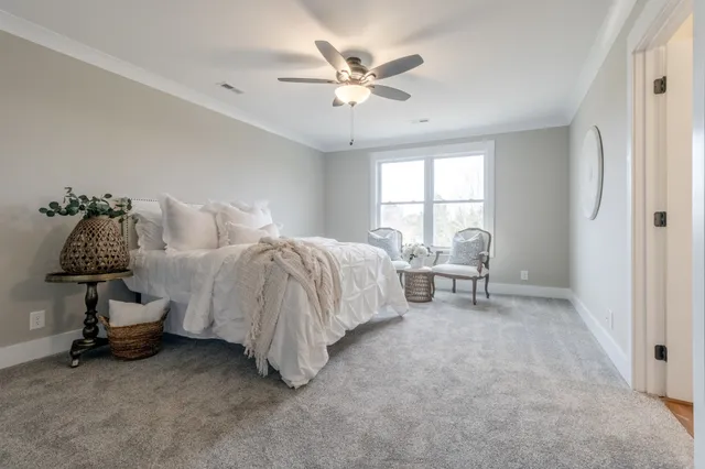 a spacious bedroom with a bed and a chandelier
