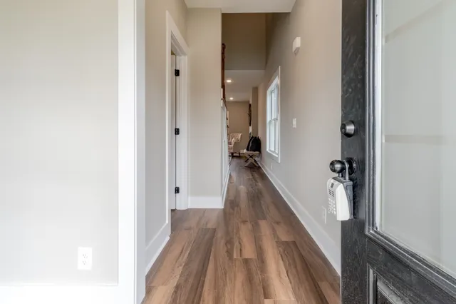 a view of a hallway with wooden floor and staircase