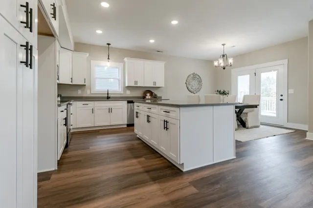 a kitchen with a sink cabinets and wooden floor