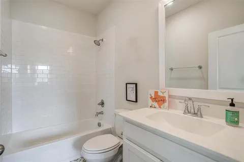 a bathroom with a granite countertop sink a toilet and shower