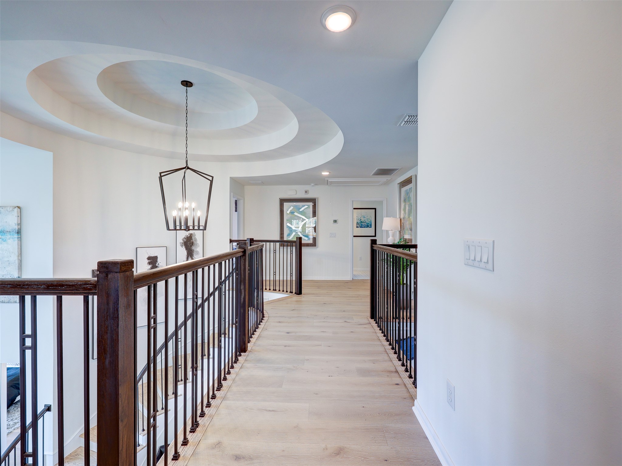 6220 Bower Well Road Austin, TX 78738 - Photo 19 of 28 A graceful curved ceiling with a statement chandelier illuminates this naturally lit upper landing.