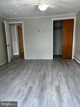 an empty room with wooden floor and closet