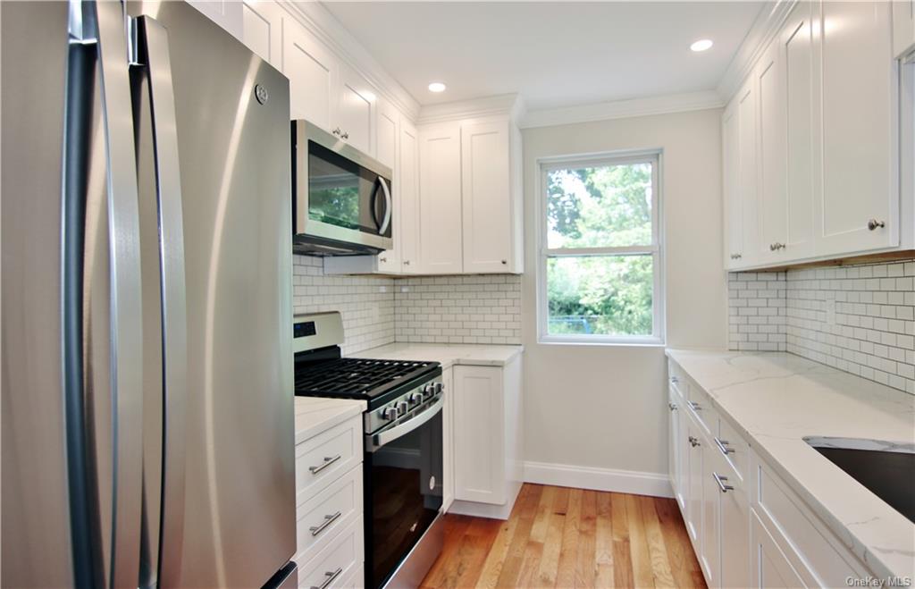 a kitchen with granite countertop a refrigerator and a sink
