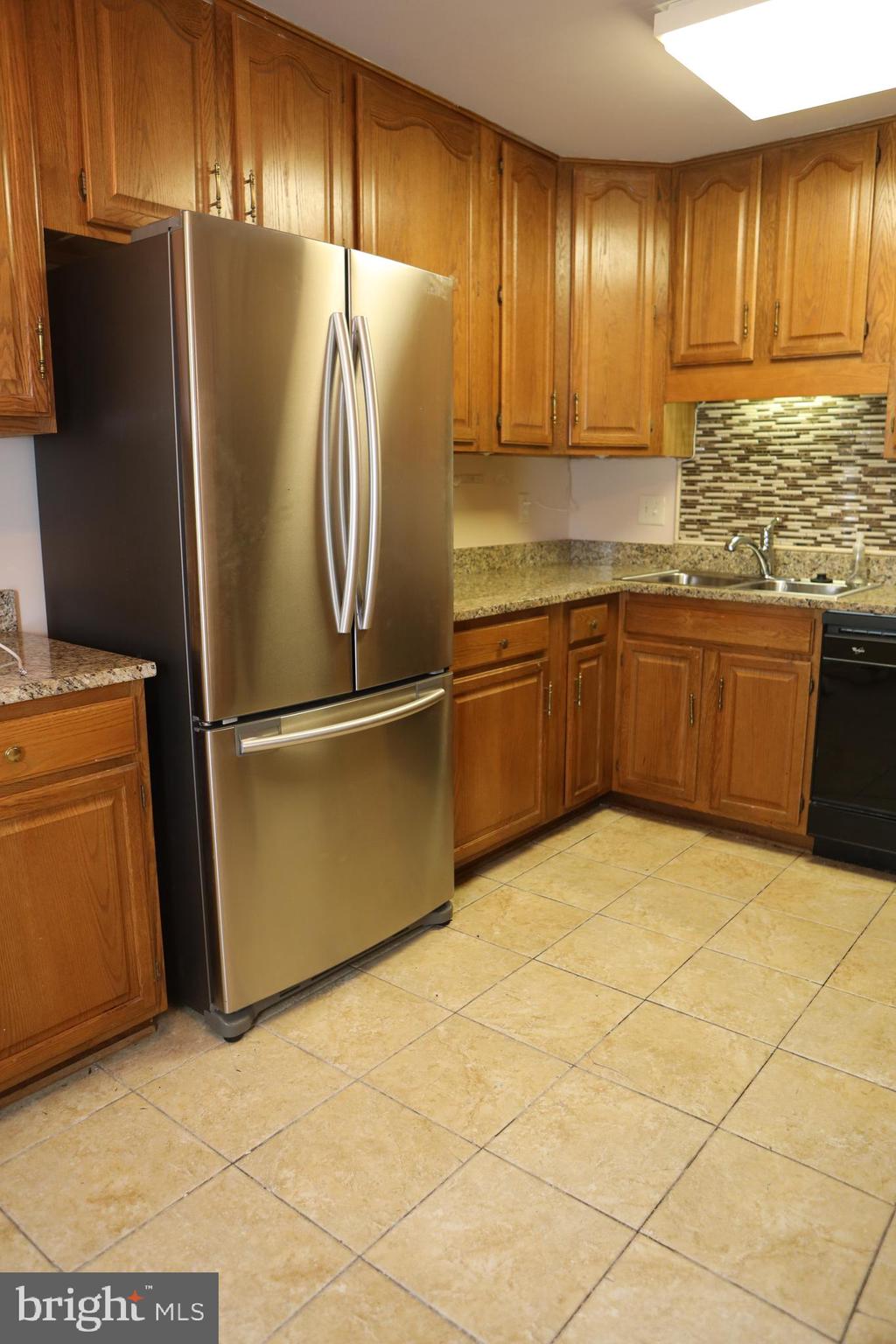 11223 Watermill Lane Silver Spring, MD 20902 - Photo 7 of 39 a kitchen with granite countertop a refrigerator and a sink