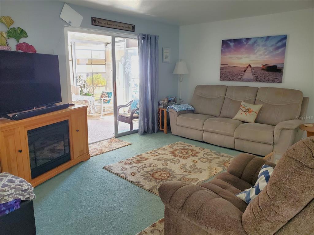 176 West Manatee Loop Punta Gorda, FL 33950 - Photo 13 of 63 a living room with furniture a flat screen tv and a fireplace